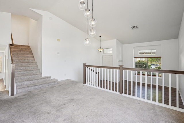 interior space featuring visible vents, carpet flooring, and lofted ceiling