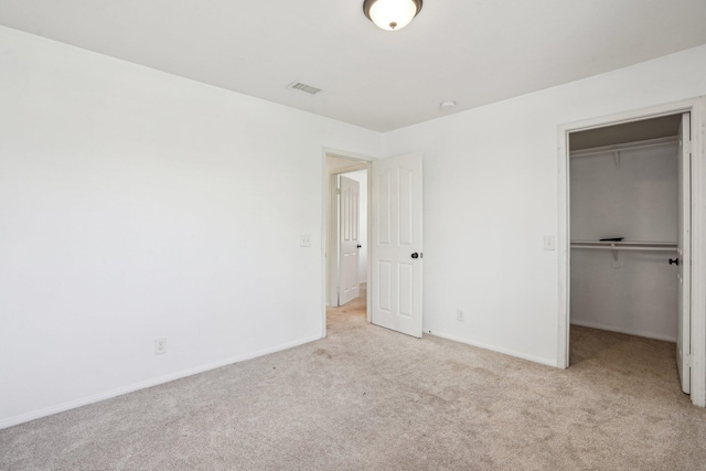 unfurnished bedroom with carpet flooring, baseboards, a spacious closet, visible vents, and a closet