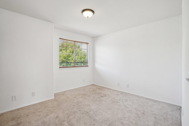 carpeted spare room with baseboards