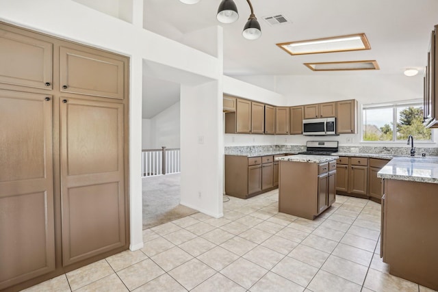 kitchen with visible vents, appliances with stainless steel finishes, a center island, light tile patterned floors, and lofted ceiling
