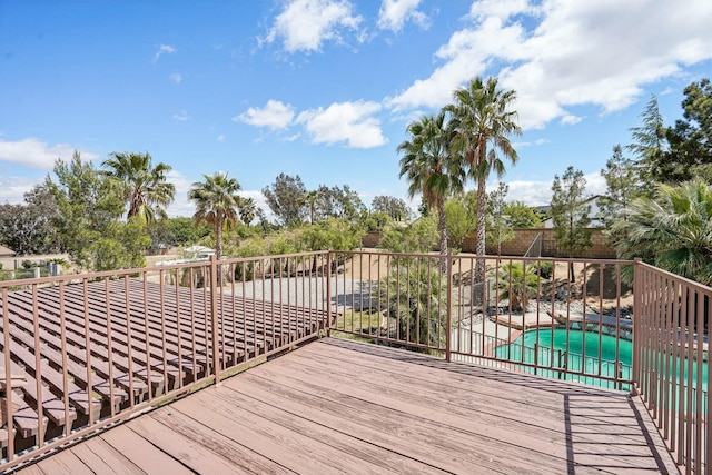 wooden terrace featuring a fenced in pool and fence