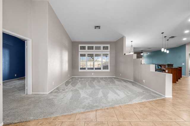 unfurnished living room featuring light tile patterned floors, visible vents, and light colored carpet