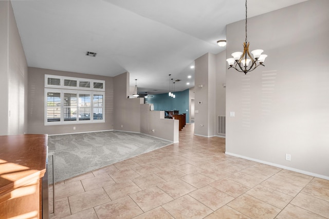 unfurnished living room with light carpet, an inviting chandelier, baseboards, and visible vents