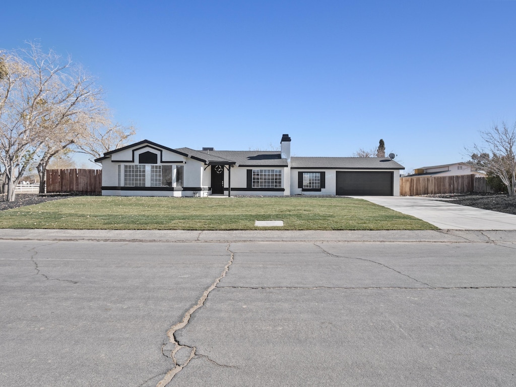 ranch-style home featuring a front yard and a garage