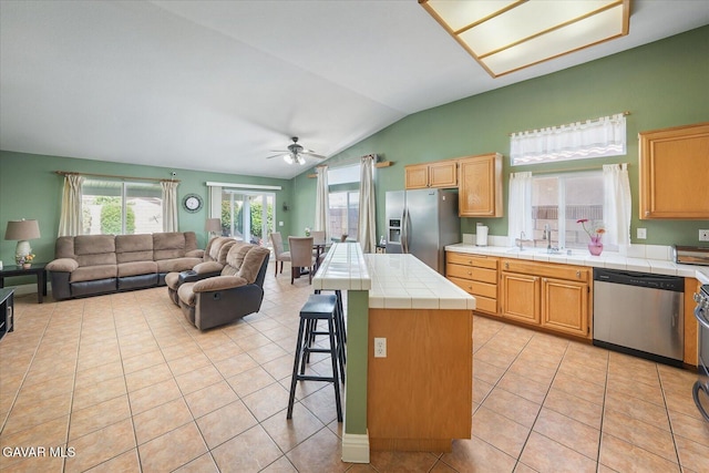 36525 Summerholly Cir, Palmdale, CA 93550 - kitchen featuring stainless steel appliances, tile counters, lofted ceiling, light tile patterned floors, and a ceiling fan