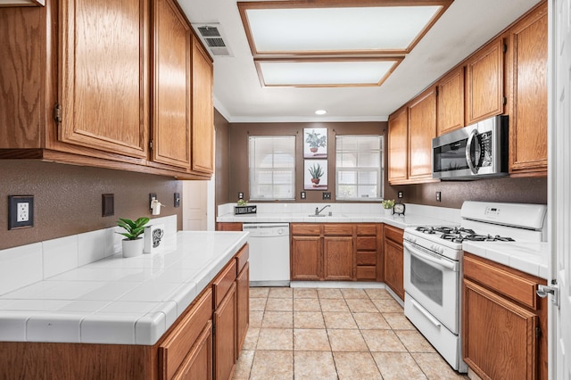 kitchen with tile countertops, sink, and white appliances