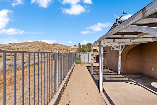 view of patio featuring a mountain view and a storage shed