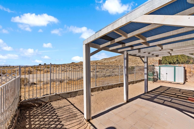 view of patio / terrace with a pergola and a storage shed