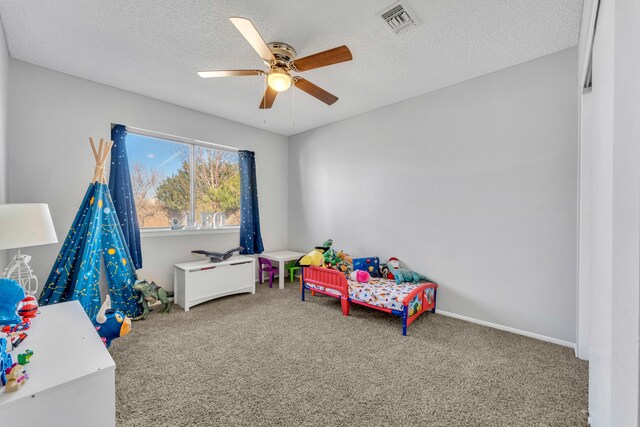 recreation room featuring carpet, a textured ceiling, and ceiling fan