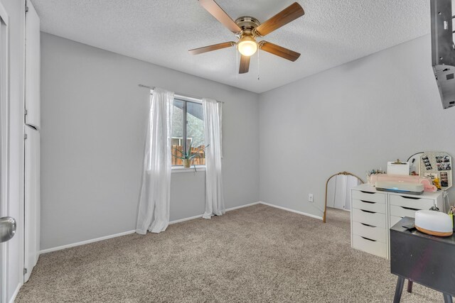 carpeted office with ceiling fan and a textured ceiling