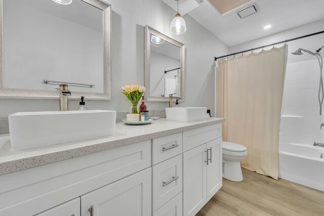 full bathroom with hardwood / wood-style flooring, vanity, toilet, and shower / tub combo