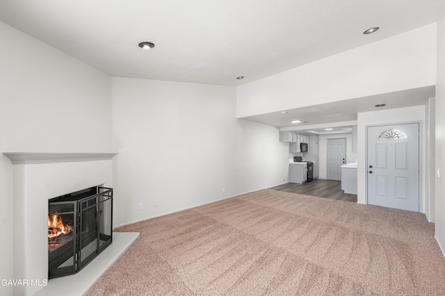 37632 E 15th St, Palmdale, CA 93550 - unfurnished living room featuring light colored carpet, a warm lit fireplace, and recessed lighting