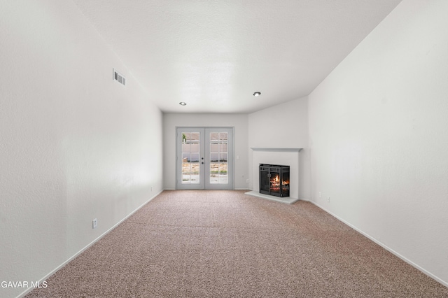 37632 E 15th St, Palmdale, CA 93550 - unfurnished living room featuring a lit fireplace, light colored carpet, and french doors