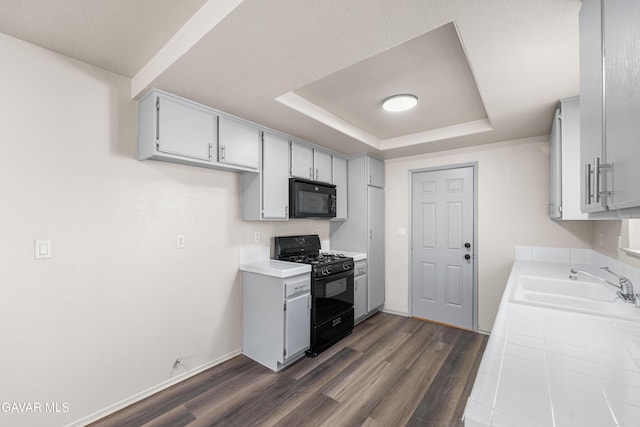 37632 E 15th St, Palmdale, CA 93550 - kitchen featuring black appliances, tile countertops, a raised ceiling, and dark wood-style floors