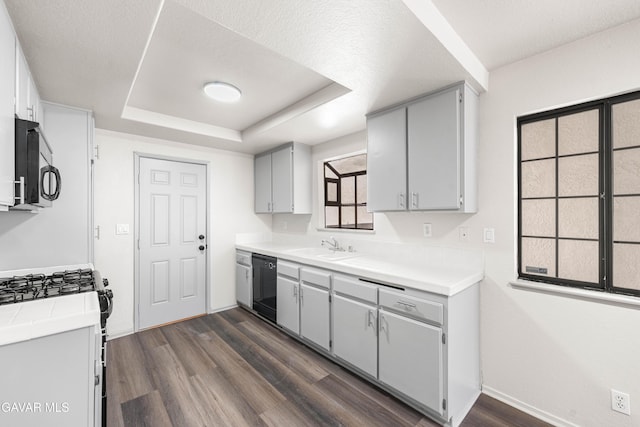 37632 E 15th St, Palmdale, CA 93550 - kitchen featuring dishwasher, dark wood-type flooring, a raised ceiling, light countertops, and range with gas stovetop
