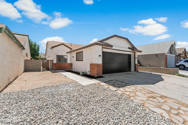 37632 E 15th St, Palmdale, CA 93550 - view of front of home with an attached garage, driveway, and brick siding