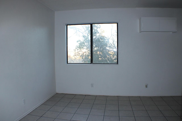 unfurnished room with light tile patterned floors and a wall unit AC