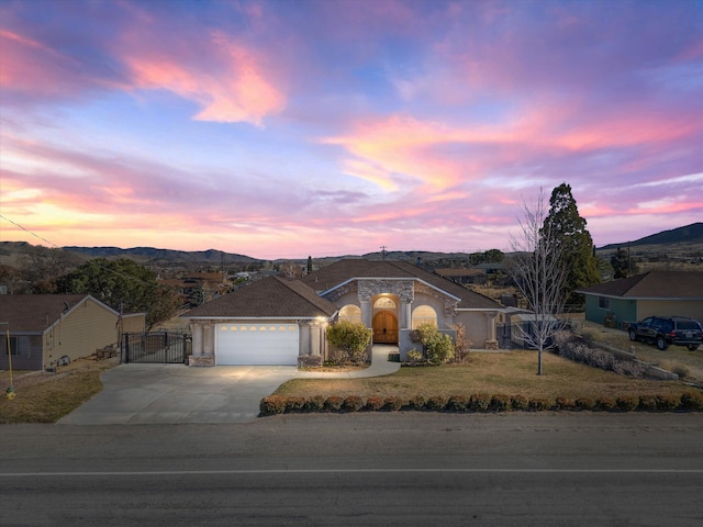 view of front of property with a mountain view, a garage, and a yard