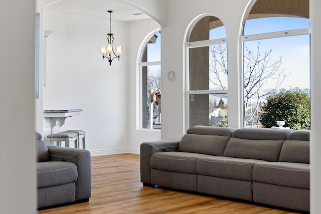 living room with light wood-type flooring and a notable chandelier