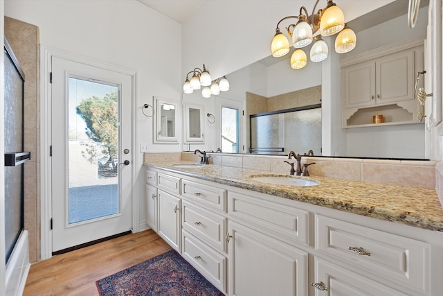 bathroom with a wealth of natural light, hardwood / wood-style floors, vanity, and a chandelier