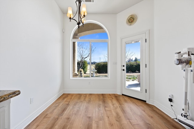 interior space with light hardwood / wood-style flooring and an inviting chandelier