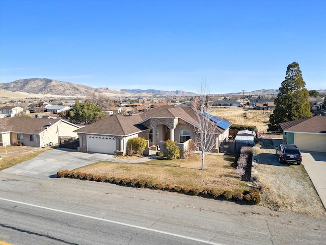 ranch-style house featuring a mountain view, a garage, and a front lawn