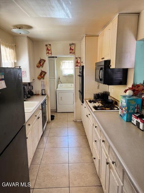 45529 Sancroft Ave, Lancaster, CA 93535 - kitchen featuring washer / dryer, black appliances, light tile patterned flooring, and light countertops