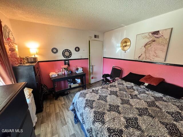 45529 Sancroft Ave, Lancaster, CA 93535 - bedroom featuring a textured ceiling and wood finished floors