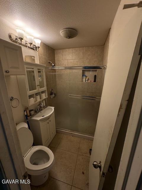 45529 Sancroft Ave, Lancaster, CA 93535 - full bath featuring a stall shower, a textured ceiling, tile patterned flooring, and vanity