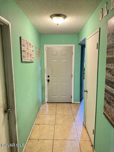 45529 Sancroft Ave, Lancaster, CA 93535 - hallway featuring a textured ceiling and light tile patterned floors