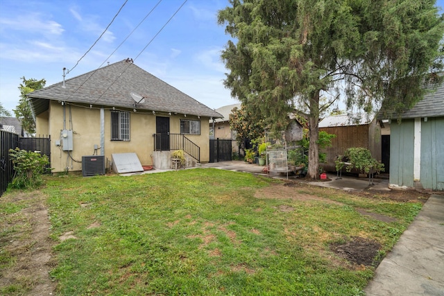 1320 W 50th St, Los Angeles, CA 90037 - rear view of property with stucco siding, fence, central air condition unit, a yard, and roof with shingles