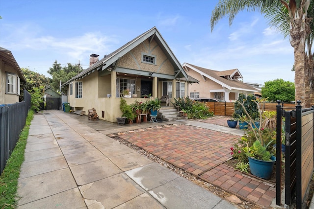 1320 W 50th St, Los Angeles, CA 90037 - back of house featuring a fenced backyard, a patio, stucco siding, and a chimney