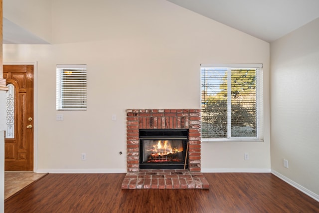 unfurnished living room featuring dark wood-type flooring, a fireplace, and vaulted ceiling