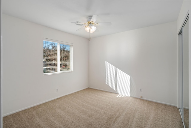 unfurnished room with light colored carpet and ceiling fan