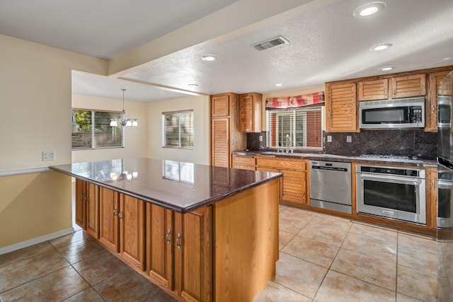 kitchen featuring light tile patterned floors, backsplash, dark stone counters, and appliances with stainless steel finishes