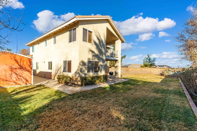 view of property exterior with a balcony and a lawn