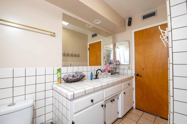 bathroom with toilet, tile patterned floors, visible vents, decorative backsplash, and vanity