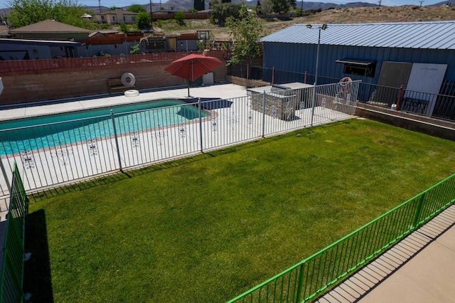 community pool with a yard, a patio area, a mountain view, and fence