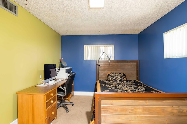 bedroom with carpet flooring, a textured ceiling, visible vents, and baseboards