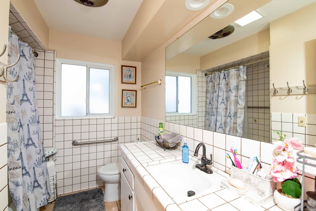 bathroom featuring tile walls, toilet, a shower with shower curtain, and vanity