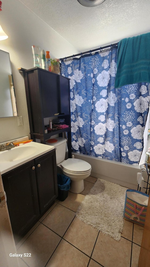 full bathroom with tile patterned floors, a textured ceiling, toilet, shower / tub combo with curtain, and vanity