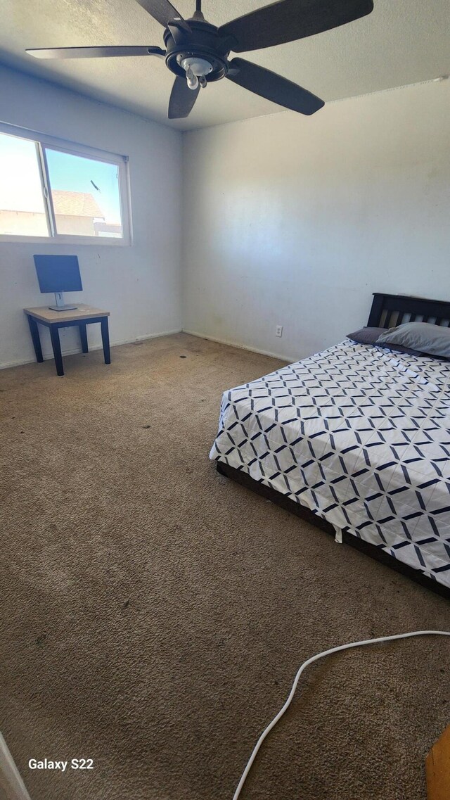 unfurnished bedroom featuring ceiling fan and carpet