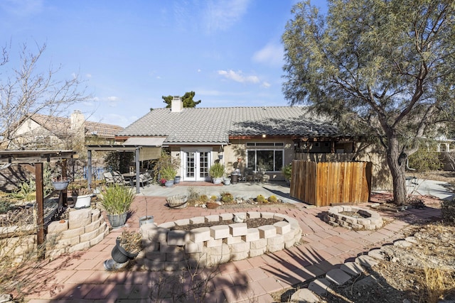 back of property with a patio area, an outdoor fire pit, and french doors