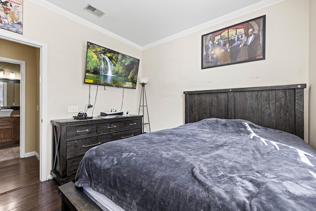 bedroom featuring dark wood-type flooring, ensuite bath, and crown molding