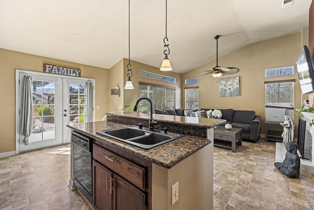 kitchen with pendant lighting, dishwasher, french doors, sink, and a kitchen island with sink