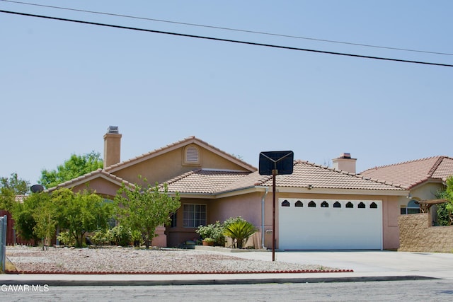 1816 Orange St, Rosamond, CA 93560 - view of front of home featuring a chimney, stucco siding, an attached garage, driveway, and a tiled roof