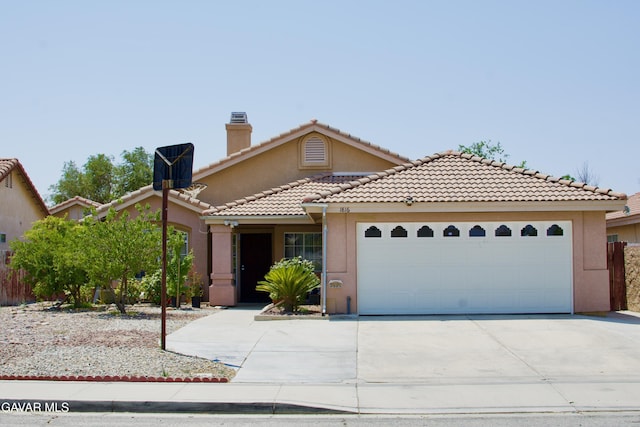 1816 Orange St, Rosamond, CA 93560 - view of front of home with stucco siding, concrete driveway, an attached garage, a tiled roof, and a chimney