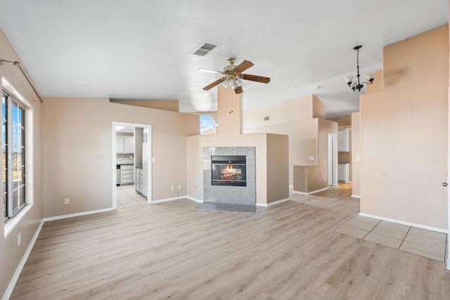 unfurnished living room with light hardwood / wood-style flooring, a tile fireplace, and ceiling fan