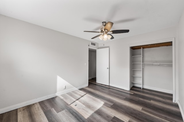 unfurnished bedroom with baseboards, wood finished floors, visible vents, and a closet