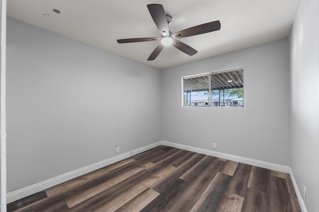 empty room featuring a ceiling fan, baseboards, and dark wood-type flooring